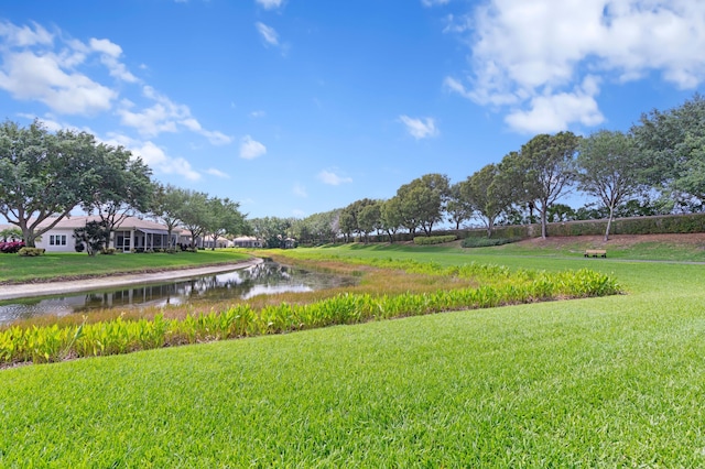 surrounding community with a water view and a yard