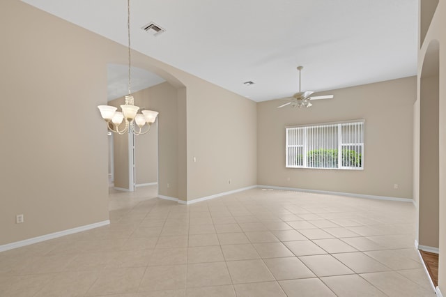 empty room featuring light tile patterned flooring, visible vents, baseboards, arched walkways, and ceiling fan with notable chandelier