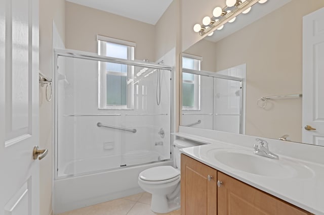 bathroom featuring tile patterned flooring, vanity, toilet, and bath / shower combo with glass door