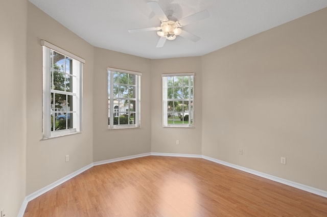 spare room featuring baseboards, light wood-style flooring, and a ceiling fan
