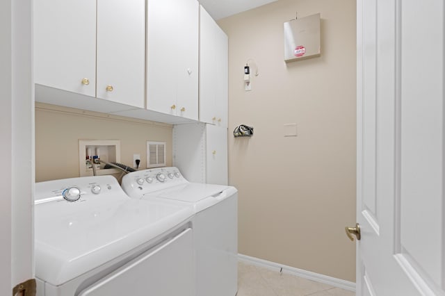 washroom with light tile patterned flooring, cabinet space, independent washer and dryer, and baseboards