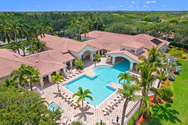 community pool with a fenced backyard and a patio area