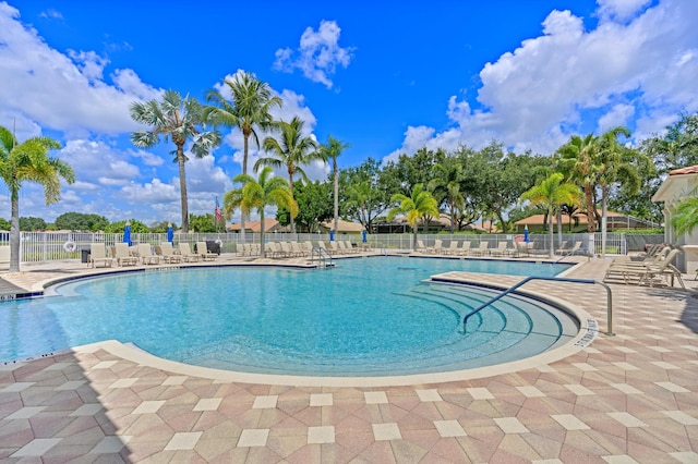 community pool featuring fence and a patio