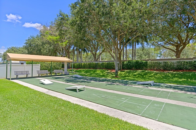 surrounding community featuring shuffleboard and a yard