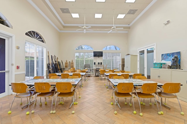dining area featuring a towering ceiling, ornamental molding, and a healthy amount of sunlight
