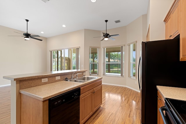 kitchen featuring light wood-type flooring, black appliances, a sink, and a ceiling fan