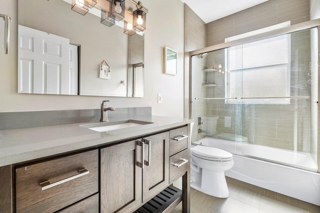 bathroom featuring toilet, vanity, and combined bath / shower with glass door