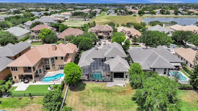 aerial perspective of suburban area with a pool area and a nearby body of water