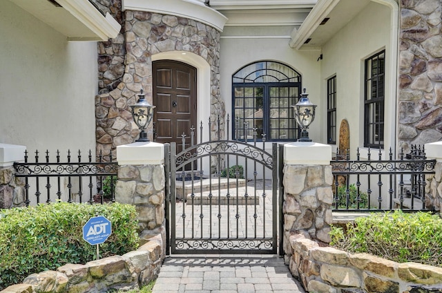9210 Equus Cir, Boynton Beach, FL 33472 - property entrance with stone siding, a gate, and stucco siding