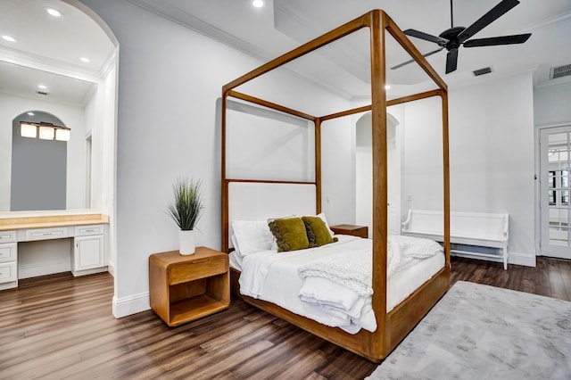 bedroom with arched walkways, crown molding, wood finished floors, baseboards, and recessed lighting