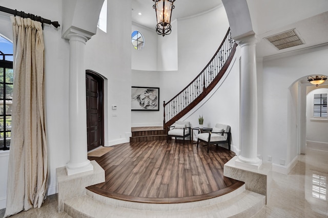 9210 Equus Cir, Boynton Beach, FL 33472 - entryway featuring ornate columns, baseboards, arched walkways, a towering ceiling, and wood finished floors