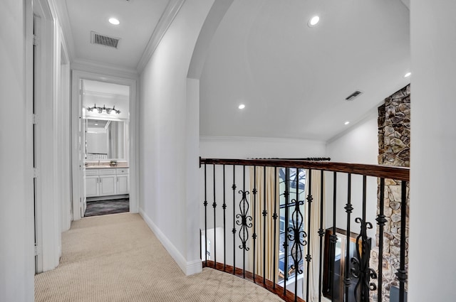 corridor with arched walkways, carpet, crown molding, baseboards, and recessed lighting