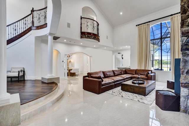 9210 Equus Cir, Boynton Beach, FL 33472 - living area featuring arched walkways, a towering ceiling, marble tiled floors, decorative columns, and crown molding