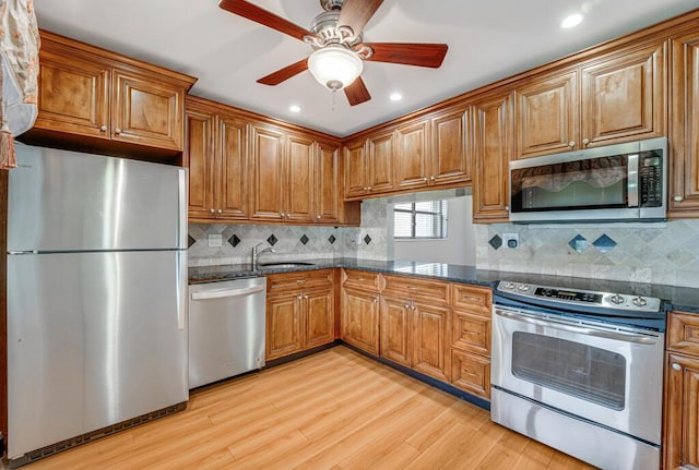 104 Lake Helen Dr, West Palm Beach, FL 33411 - kitchen with a sink, stainless steel appliances, brown cabinetry, ceiling fan, and light wood-style floors