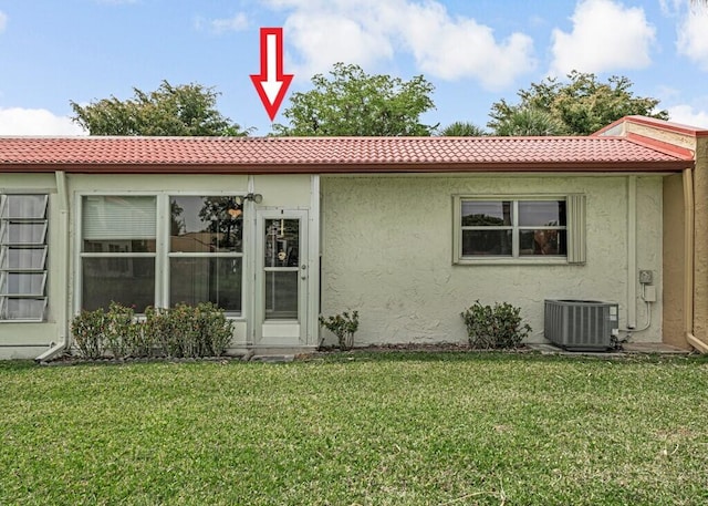 104 Lake Helen Dr, West Palm Beach, FL 33411 - back of property featuring a yard, central air condition unit, stucco siding, and a tile roof