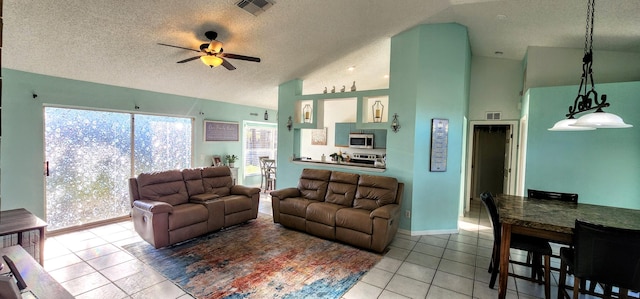 living room featuring vaulted ceiling, a textured ceiling, tile patterned floors, and ceiling fan