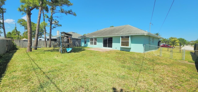 back of property with a playground and stucco siding