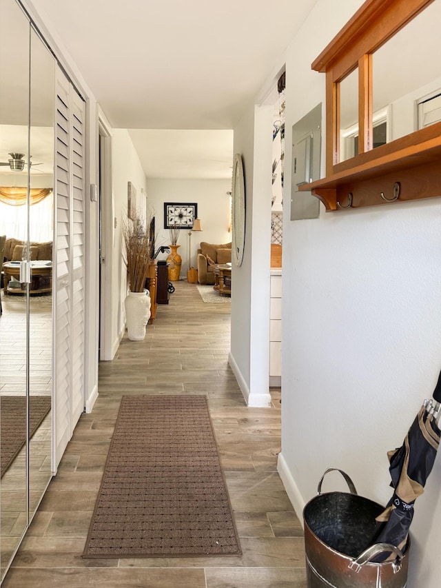 hall with baseboards and wood finished floors