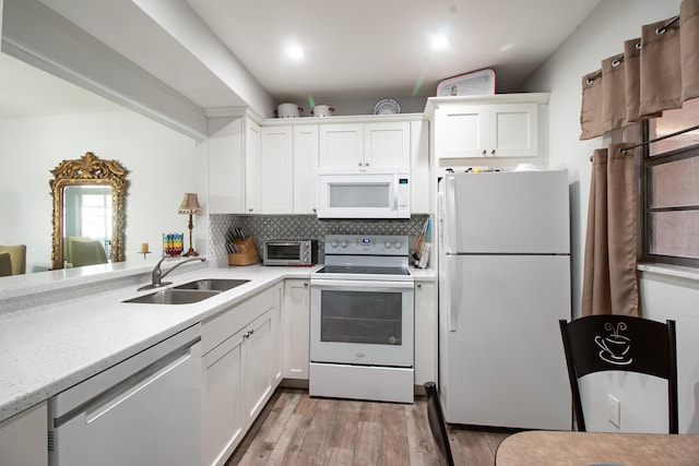 kitchen featuring white appliances, a sink, light countertops, and tasteful backsplash