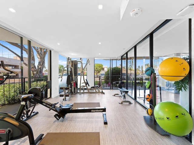 workout area with recessed lighting, a healthy amount of sunlight, and a wall of windows
