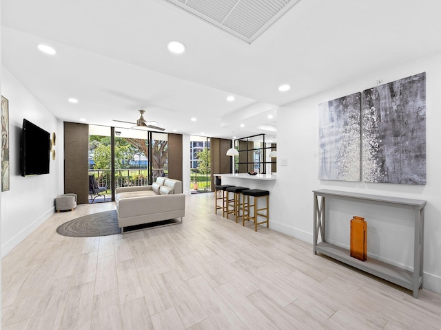 living area featuring recessed lighting, baseboards, floor to ceiling windows, visible vents, and ceiling fan