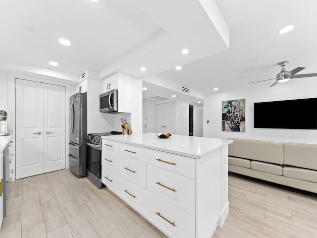kitchen with modern cabinets, white cabinets, stainless steel appliances, and a ceiling fan