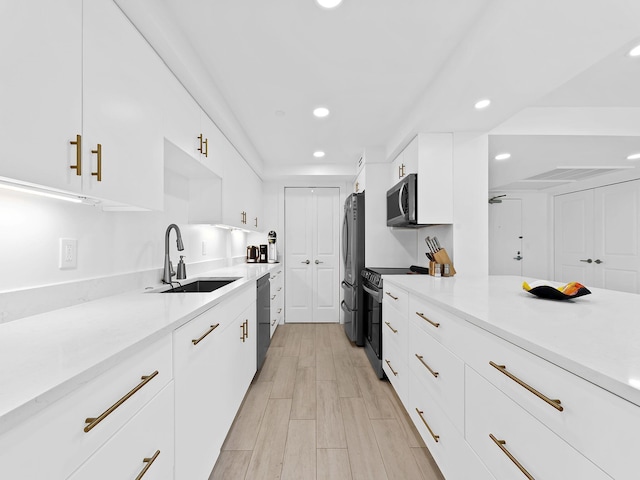 kitchen featuring white cabinetry, recessed lighting, a sink, modern cabinets, and appliances with stainless steel finishes