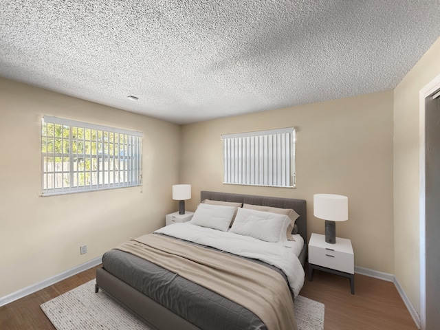 6875 NW 1st Ct, Margate, FL 33063 - bedroom with a textured ceiling, wood finished floors, and baseboards