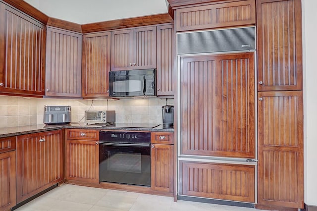 13315 Deauville Dr, Palm Beach Gardens, FL 33410 - kitchen with dark stone counters, light tile patterned floors, tasteful backsplash, and black appliances