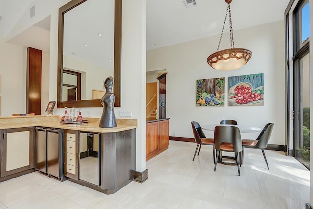 13315 Deauville Dr, Palm Beach Gardens, FL 33410 - interior space featuring light countertops, pendant lighting, refrigerator, baseboards, and visible vents