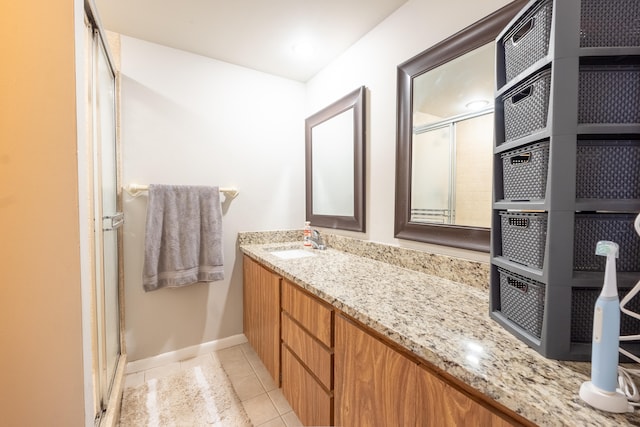 bathroom with baseboards, a shower stall, tile patterned floors, and vanity