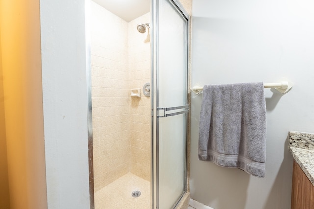 bathroom with a shower stall and vanity