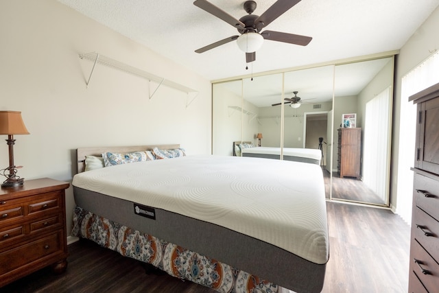 bedroom with ceiling fan, a closet, wood finished floors, and visible vents