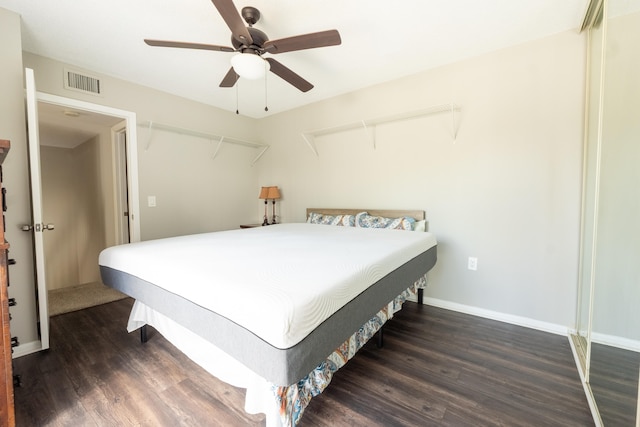 bedroom with visible vents, a ceiling fan, baseboards, and wood finished floors