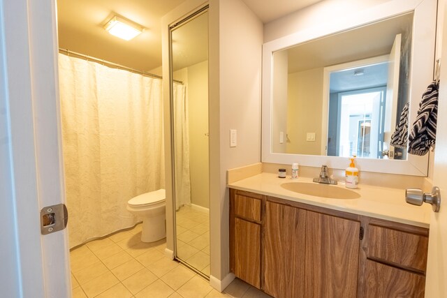 bathroom with toilet, tile patterned floors, and vanity
