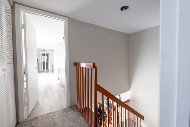 hall with an upstairs landing and carpet