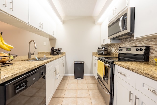 kitchen with a sink, decorative backsplash, white cabinets, and stainless steel appliances