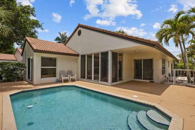 22586 Esplanada Dr, Boca Raton, FL 33433 - back of property with stucco siding, a tiled roof, a patio, and an outdoor pool