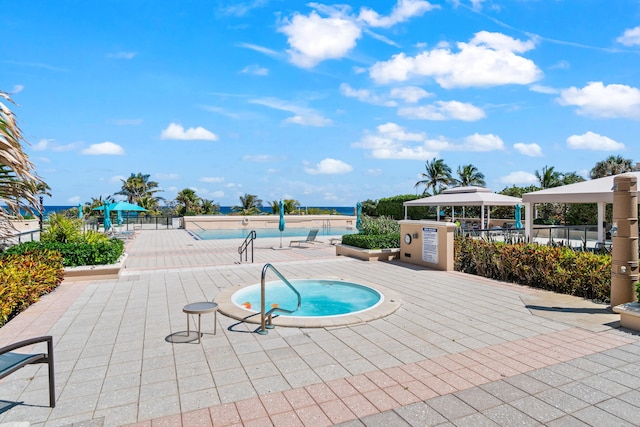 pool featuring a hot tub, a gazebo, fence, and a patio area