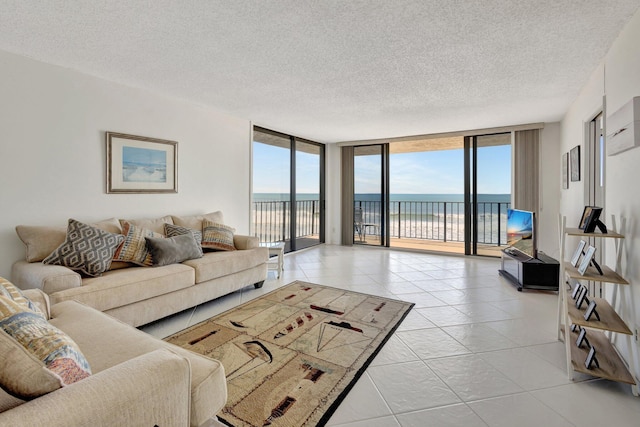 10000 S Ocean Dr S Unit 601, Jensen Beach, FL 34957 - living room featuring floor to ceiling windows, light tile patterned floors, and a textured ceiling