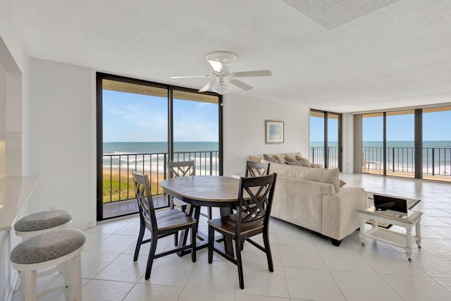 10000 S Ocean Dr S Unit 601, Jensen Beach, FL 34957 - dining room featuring floor to ceiling windows, a wealth of natural light, a water view, and ceiling fan