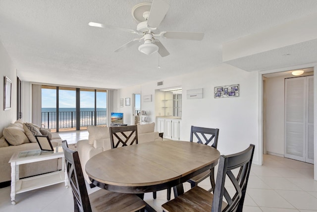 10000 S Ocean Dr S Unit 601, Jensen Beach, FL 34957 - dining room with expansive windows, light tile patterned floors, a textured ceiling, visible vents, and ceiling fan