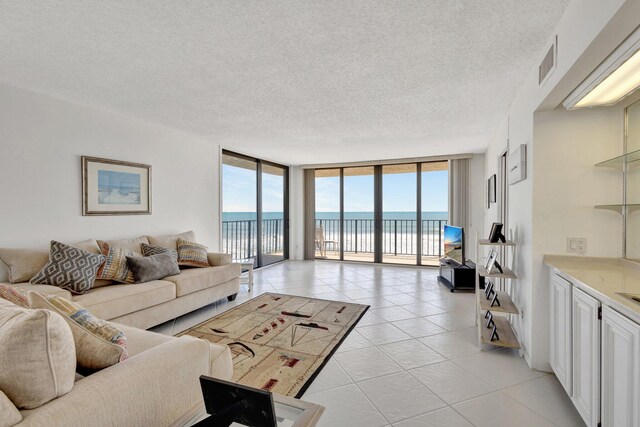 10000 S Ocean Dr S Unit 601, Jensen Beach, FL 34957 - living area featuring light tile patterned flooring, a textured ceiling, expansive windows, and visible vents