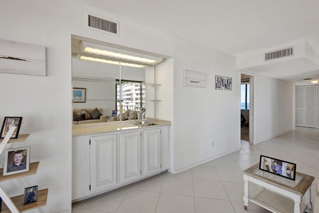 10000 S Ocean Dr S Unit 601, Jensen Beach, FL 34957 - interior space with light tile patterned flooring, visible vents, a sink, and a textured ceiling