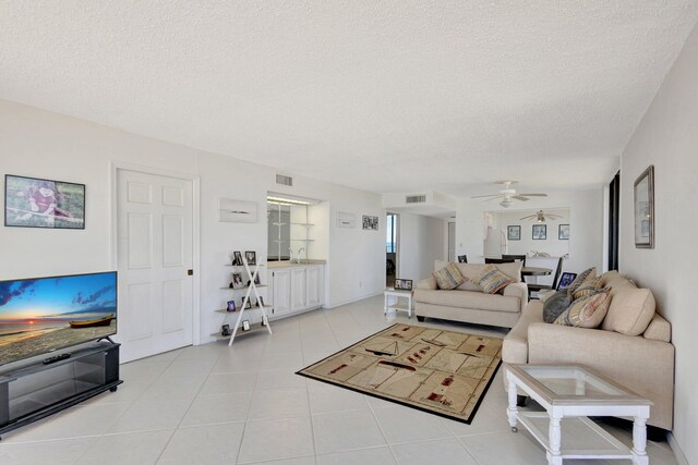 10000 S Ocean Dr S Unit 601, Jensen Beach, FL 34957 - living area with a ceiling fan, light tile patterned flooring, a textured ceiling, and visible vents