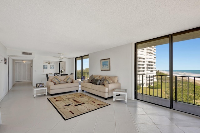 10000 S Ocean Dr S Unit 601, Jensen Beach, FL 34957 - living room with light tile patterned flooring, expansive windows, visible vents, and a ceiling fan