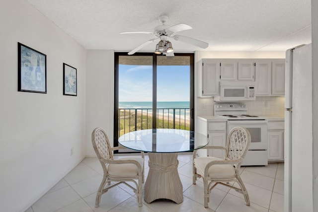 10000 S Ocean Dr S Unit 601, Jensen Beach, FL 34957 - dining room with a textured ceiling, expansive windows, ceiling fan, and a water view