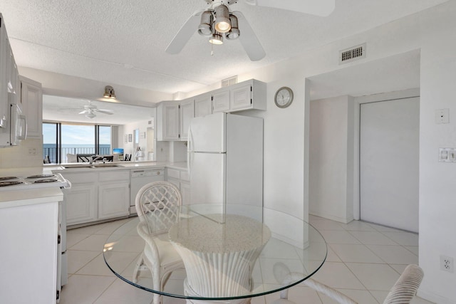 10000 S Ocean Dr S Unit 601, Jensen Beach, FL 34957 - dining area featuring a textured ceiling, visible vents, ceiling fan, and light tile patterned floors