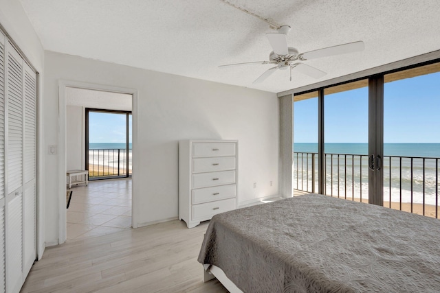 10000 S Ocean Dr S Unit 601, Jensen Beach, FL 34957 - bedroom with light wood-style floors, access to exterior, expansive windows, and a textured ceiling