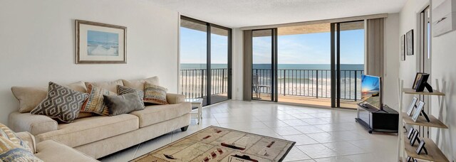 10000 S Ocean Dr S Unit 601, Jensen Beach, FL 34957 - living room featuring plenty of natural light, a wall of windows, light tile patterned floors, and a textured ceiling